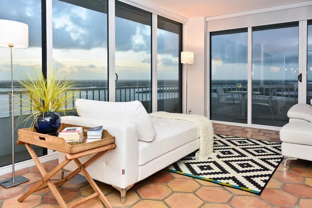 a bedroom with a bed and large window with balcony view