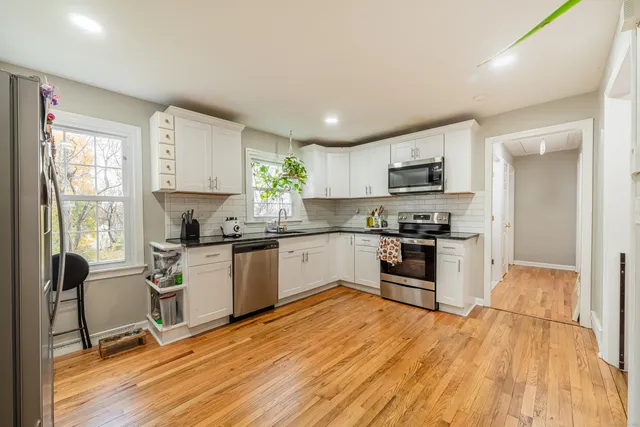 a kitchen with granite countertop a stove a sink and a refrigerator