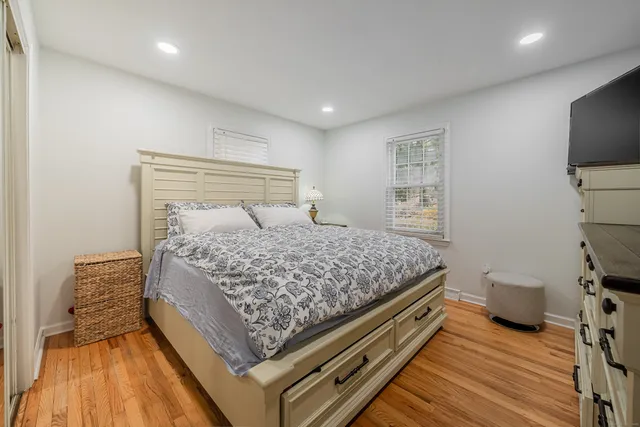 a bed sitting in a bedroom next to a window with tv