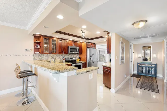 a kitchen with stainless steel appliances kitchen island granite countertop a refrigerator and a stove top oven