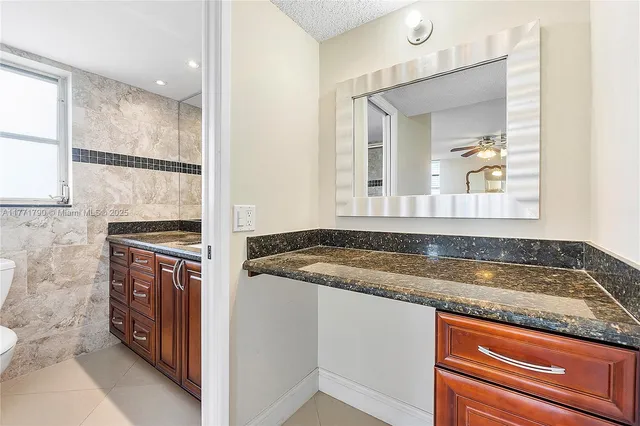 a bathroom with a granite countertop sink and mirror