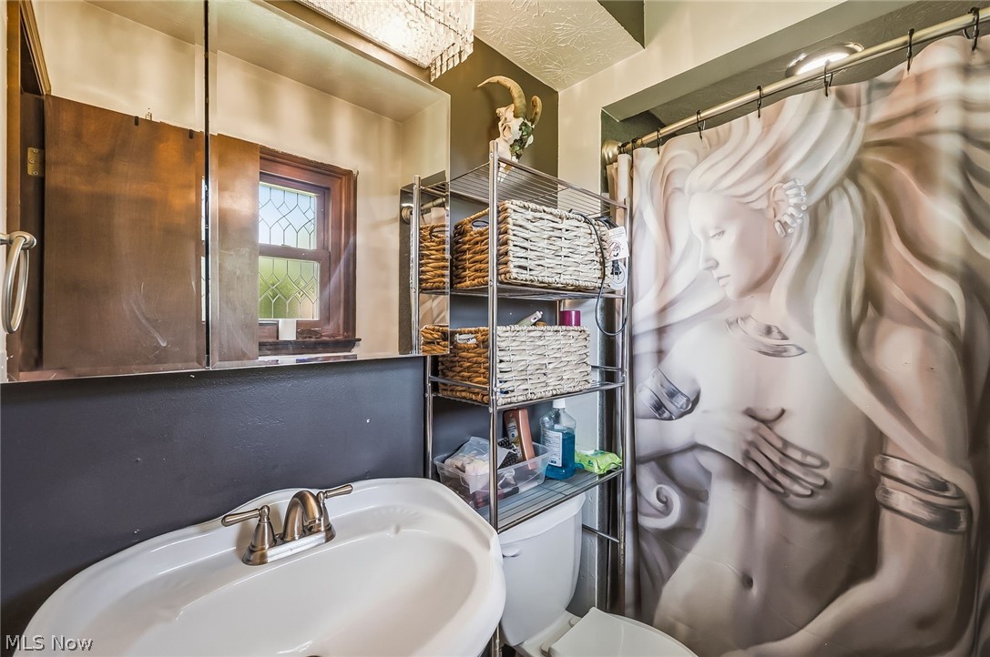 6890 Refugee Road Pickerington, OH 43147 - Photo 26 of 49 Bathroom featuring a white drop-in sink with a brushed nickel faucet, an ornate stained glass window, and a wood-finish medicine cabinet