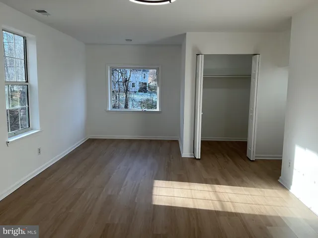 an empty room with wooden floor and window