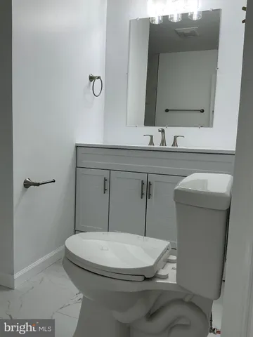 a bathroom with a sink a toilet and mirror