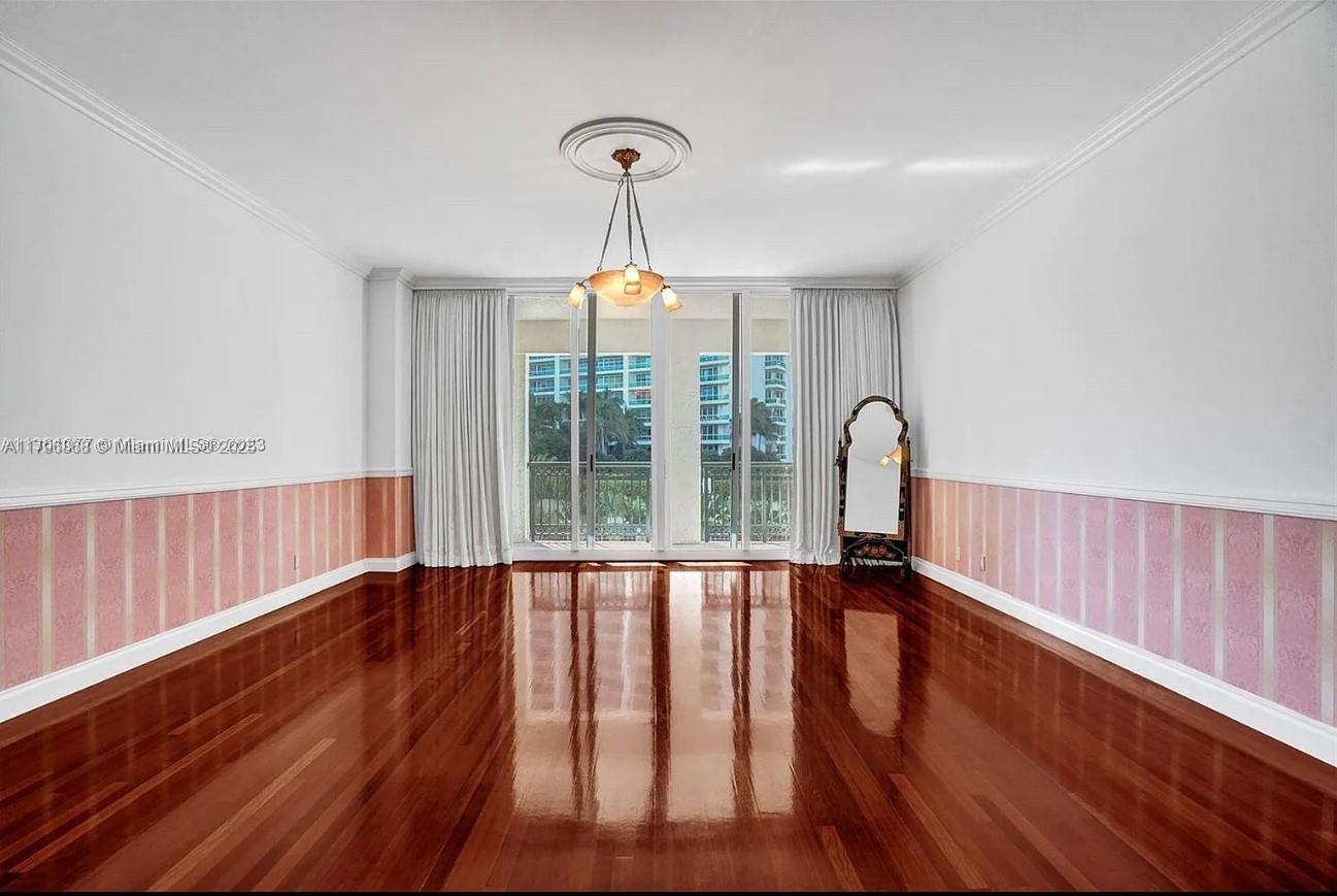 20165 Northeast 39th Place, Unit 403 Aventura, FL 33180 - Photo 12 of 40 a view of an empty room with wooden floor and fan