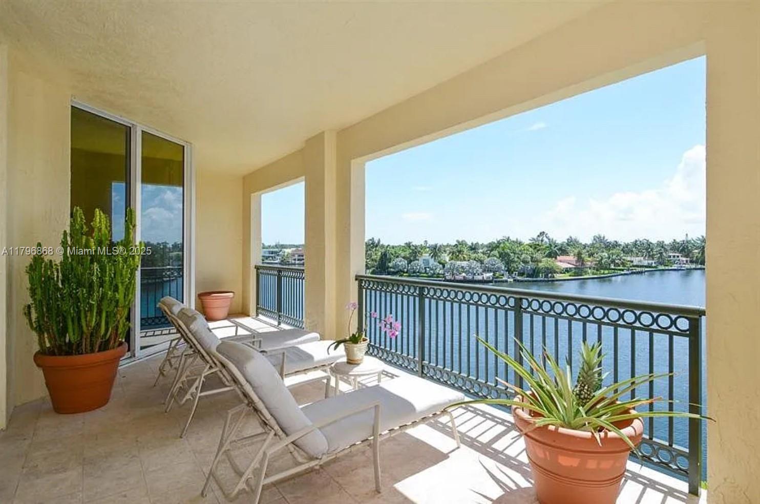 20165 Northeast 39th Place, Unit 403 Aventura, FL 33180 - Photo 15 of 40 a view of a balcony and mountain with couple of potted plants