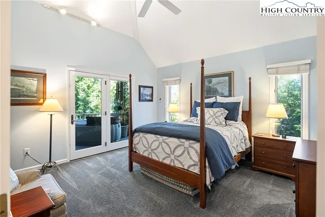 a bedroom with a bed and large windows