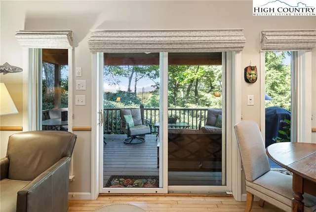 a living room with a floor to ceiling window and wooden floor