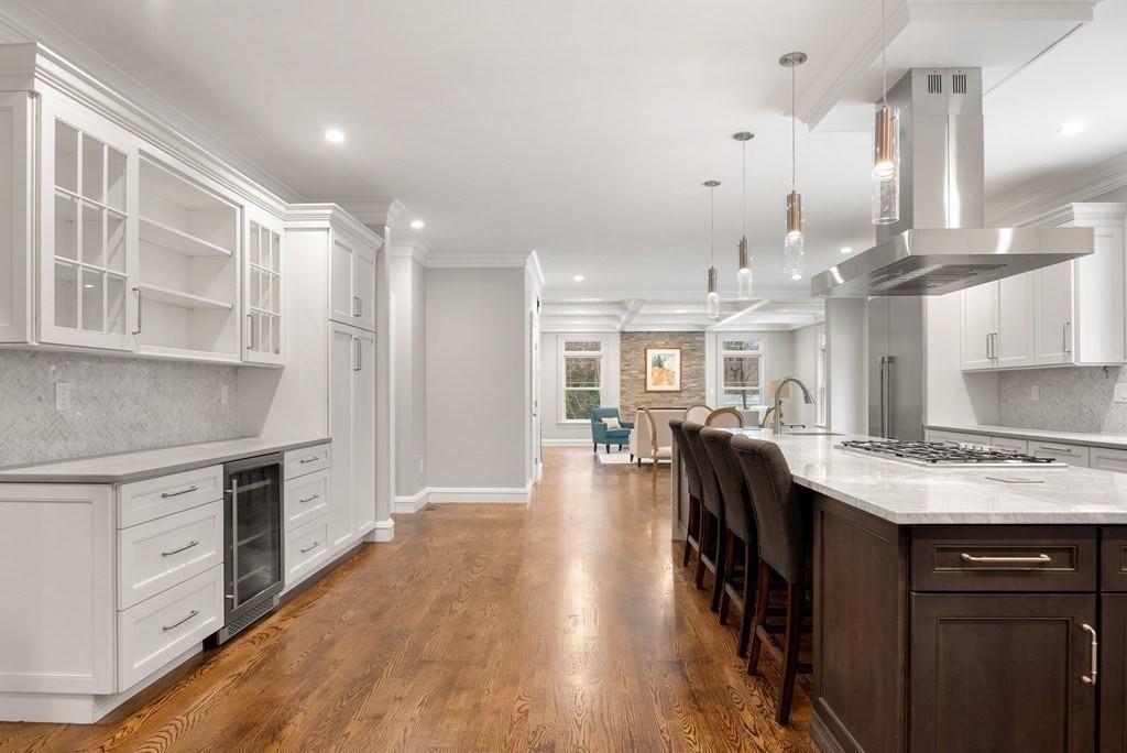 6 West Knoll Road Andover, MA 01810 - Photo 11 of 42 a open kitchen with kitchen island a stove a sink a dining table and chairs with wooden floor
