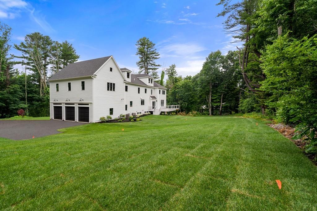 6 West Knoll Road Andover, MA 01810 - Photo 6 of 42 a white house with a small yard and big trees