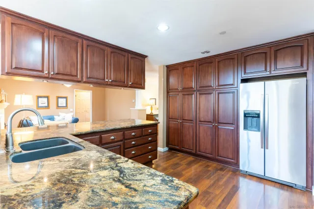 a bathroom with a granite countertop sink a large mirror and a bathtub