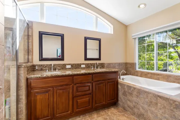 a bathroom with a granite countertop sink a large mirror and a bathtub