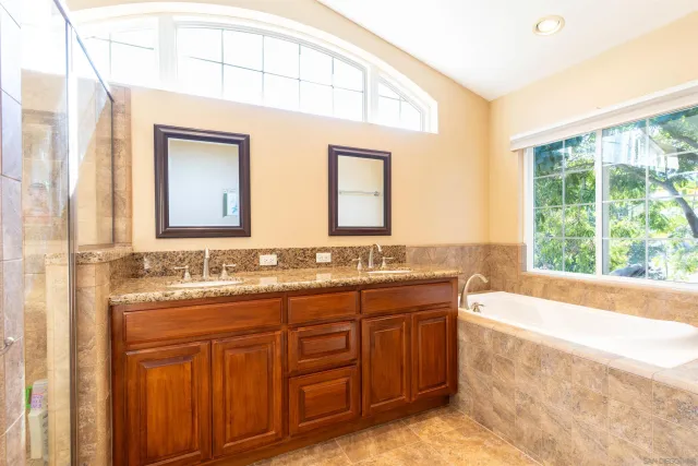 a bathroom with a granite countertop sink and a large mirror