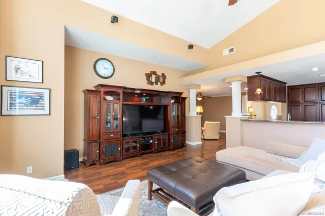 a bed sitting in a spacious bedroom next to a window and a chair