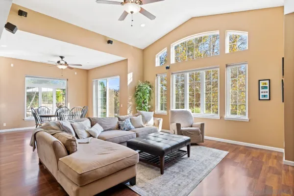 a living room with furniture and floor to ceiling windows