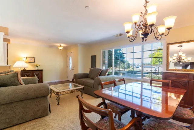 a living room with furniture a chandelier and a dining table