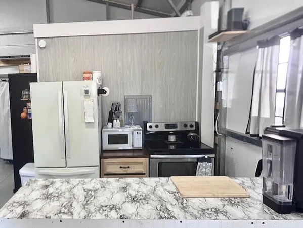 a kitchen with stainless steel appliances kitchen island sink refrigerator and stove