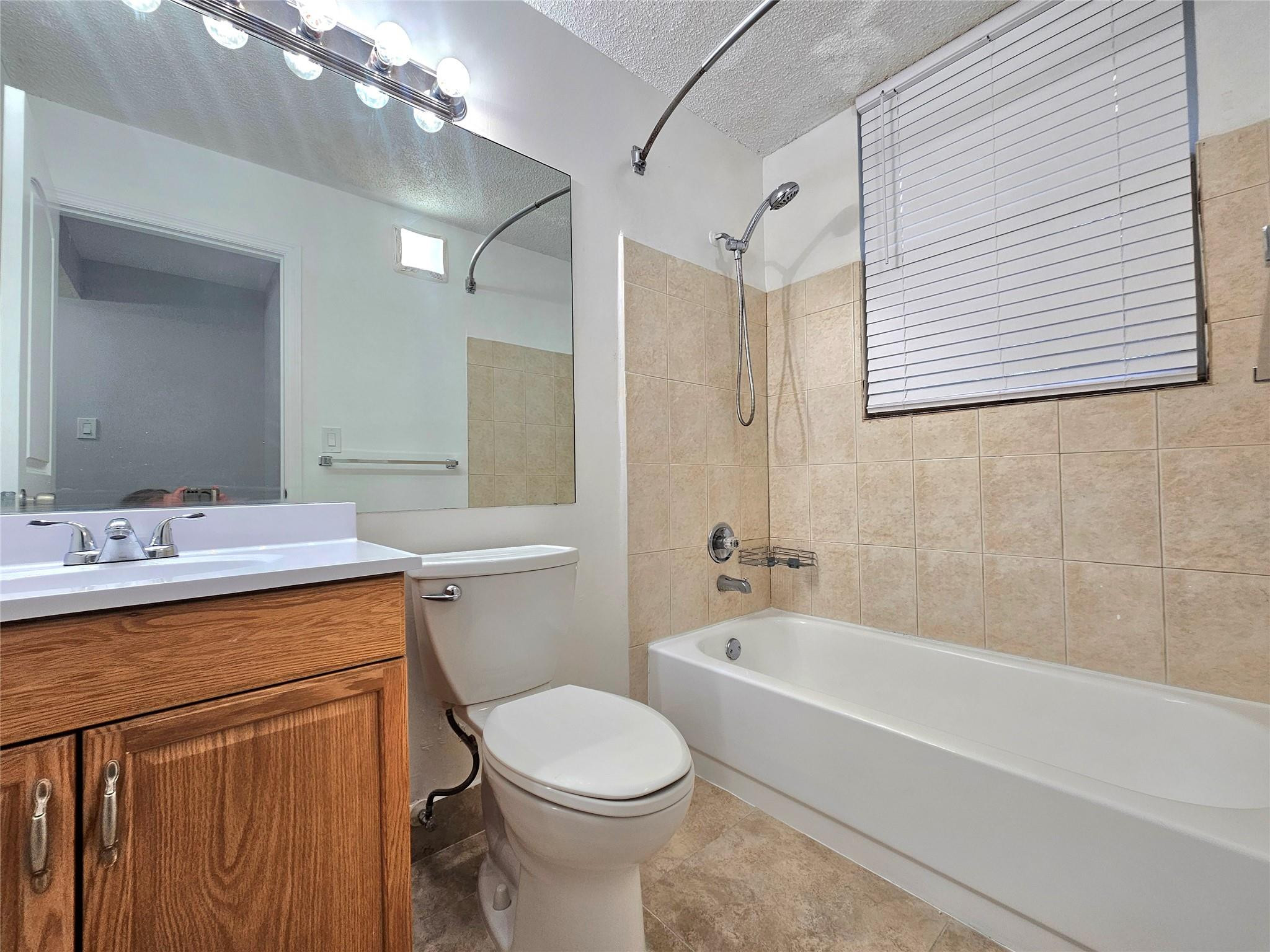 651 Lyons Road, Unit 10202 Coconut Creek, FL 33063 - Photo 7 of 28 a bathroom with a sink a toilet and shower