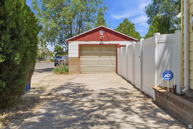 94 West 2000th Street North Clearfield, UT 84015 - Photo 18 of 26 Driveway access leading to the detached garage with additional parking and gated yard entry.