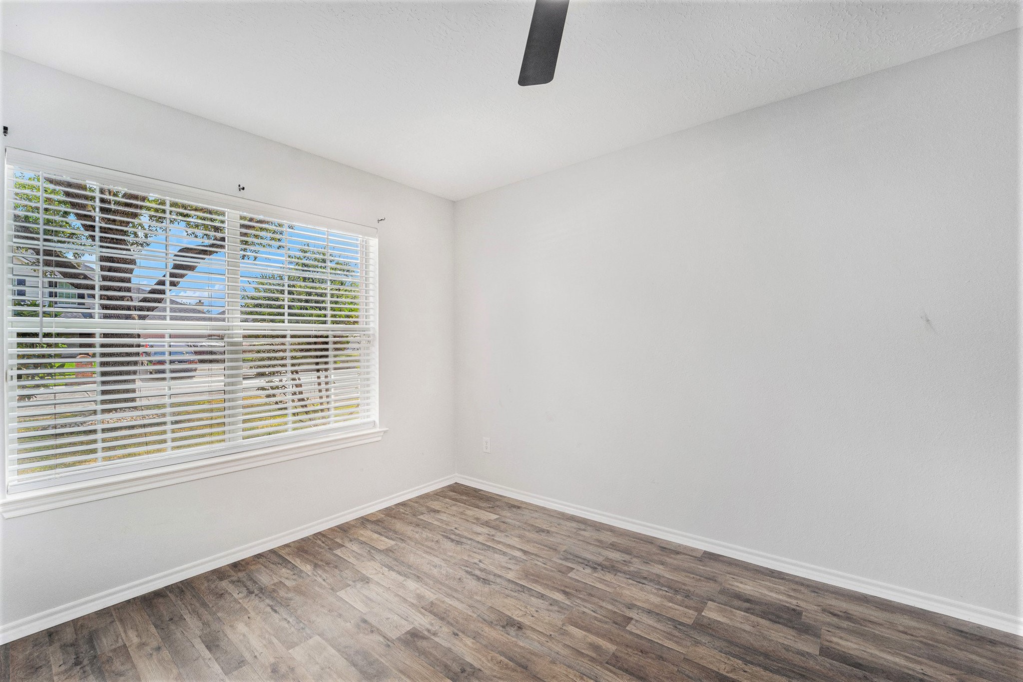 18131 Stone Trail Manor Drive Humble, TX 77346 - Photo 9 of 31 a view of an empty room with wooden floor and a window