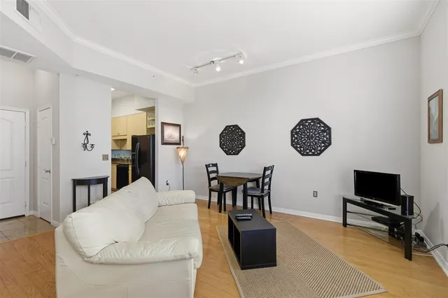 a living room with furniture kitchen view and a window