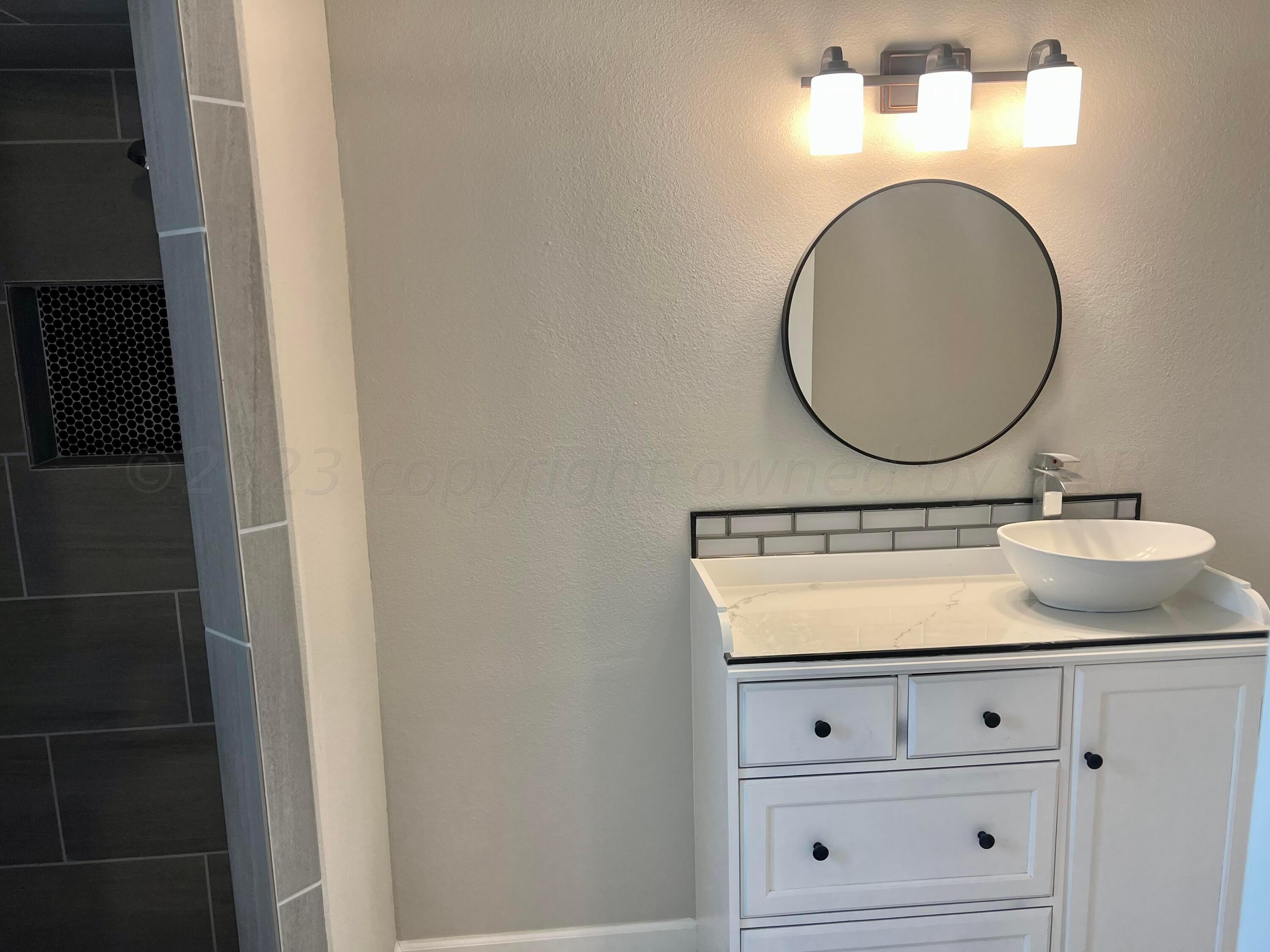 2903 Bagarry Street Amarillo, TX 79103 - Photo 12 of 26 a bathroom with a sink and a mirror