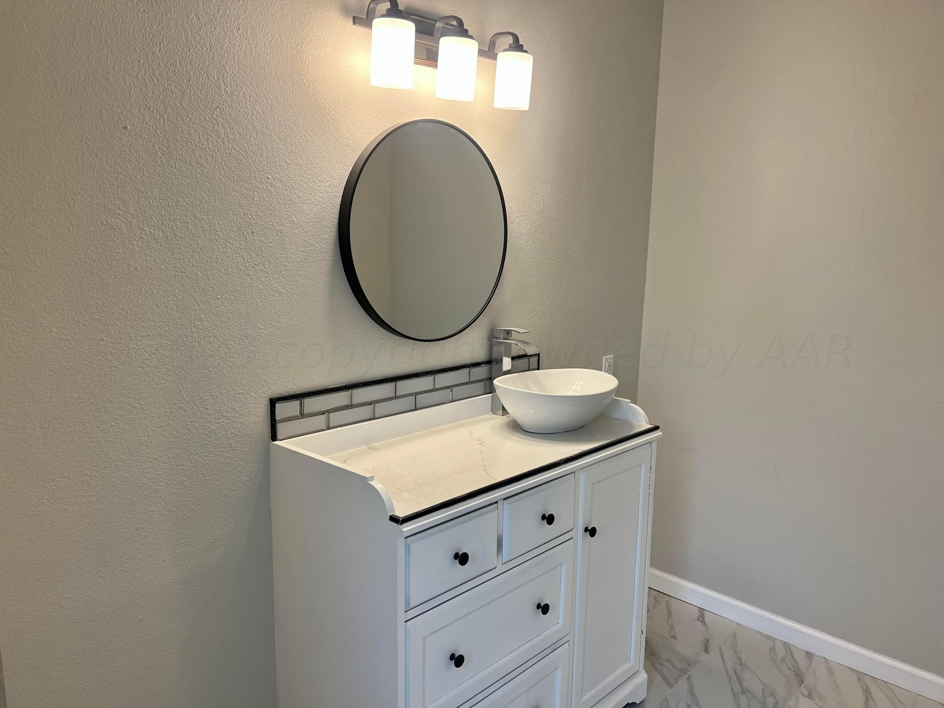 2903 Bagarry Street Amarillo, TX 79103 - Photo 13 of 26 a bathroom with a sink and a mirror
