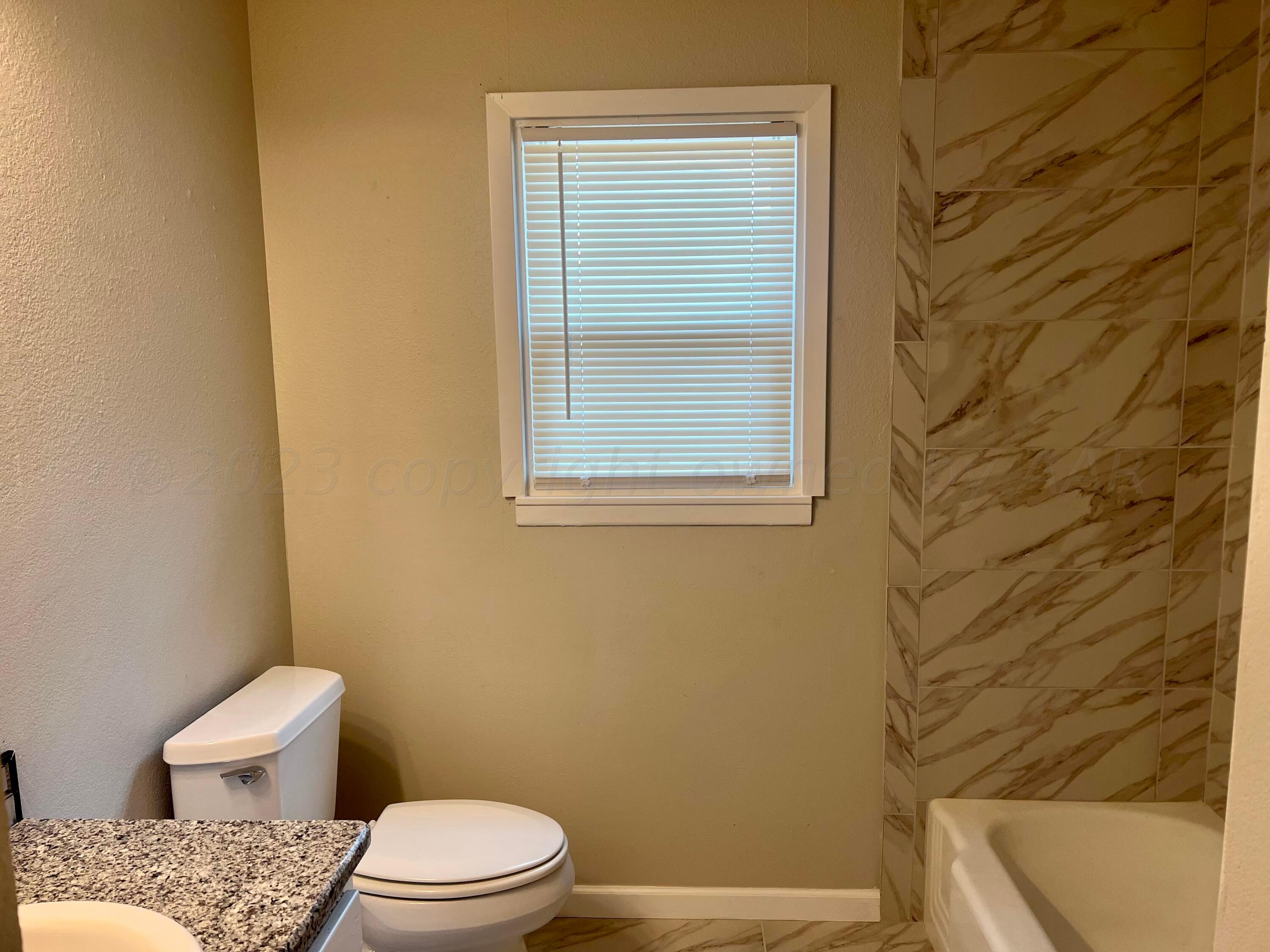 2903 Bagarry Street Amarillo, TX 79103 - Photo 18 of 26 a white toilet and a shower curtain