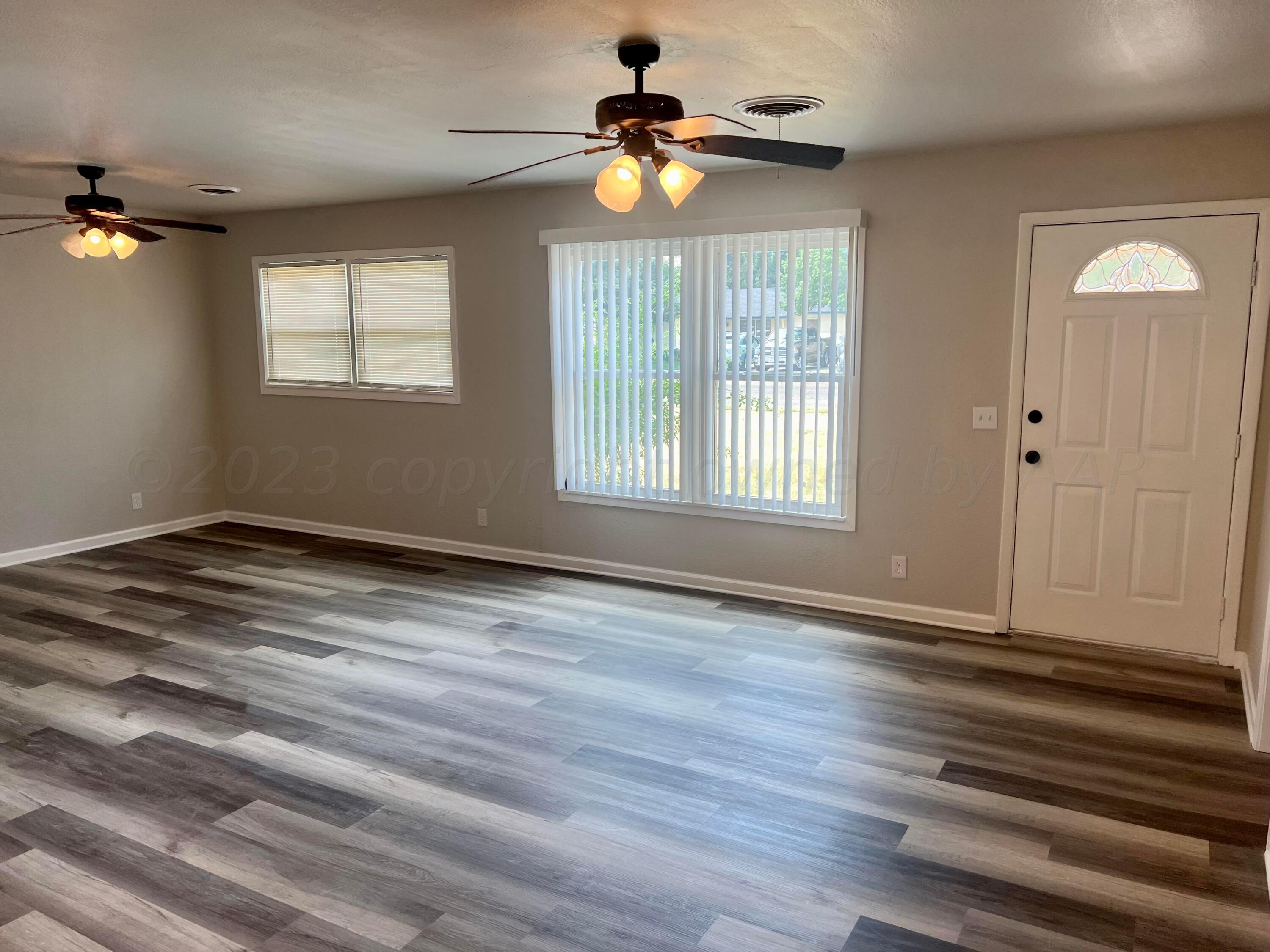 2903 Bagarry Street Amarillo, TX 79103 - Photo 3 of 26 a view of an empty room with window and chandelier fan