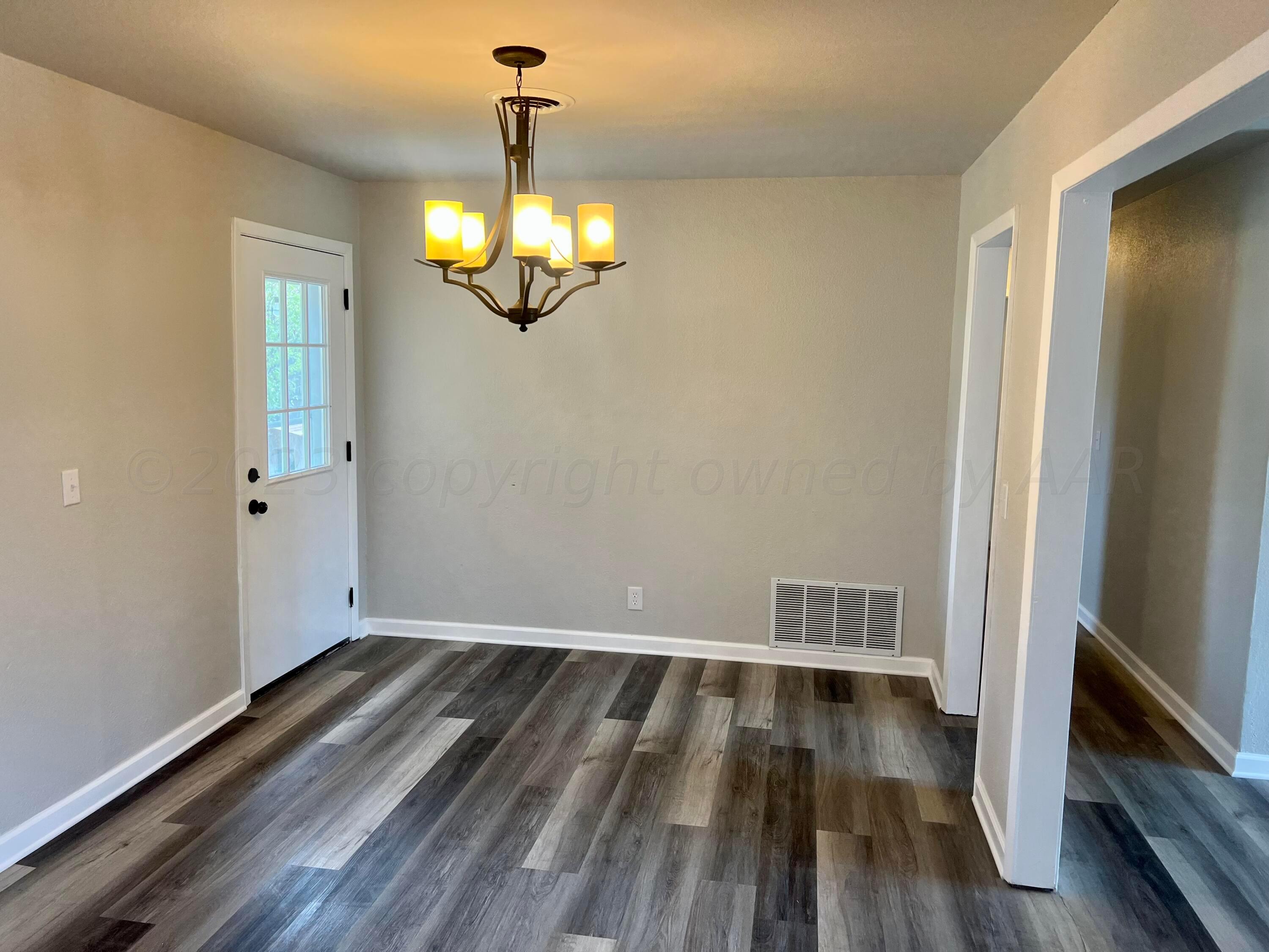 2903 Bagarry Street Amarillo, TX 79103 - Photo 7 of 26 a view of a room with wooden floor and chandelier