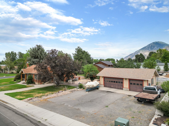 615 East Maple Street Mapleton, UT 84664 - Photo 29 of 30 Expansive paved driveway leading to a detached garage with two bay doors, offering substantial parking
