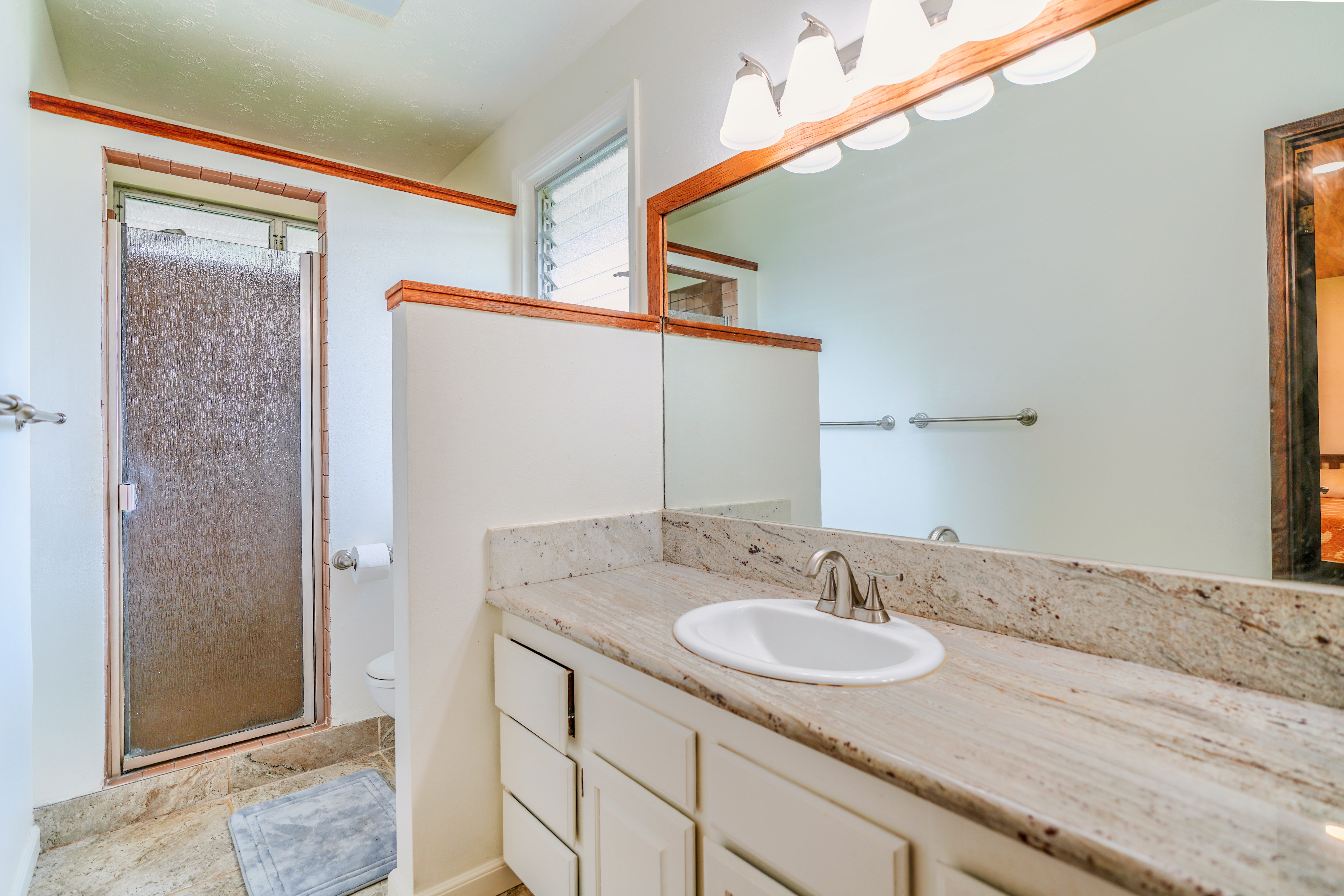316 A Makani Road, Unit A Kapaa, HI 96746 - Photo 14 of 29 a bathroom with a granite countertop sink and a mirror