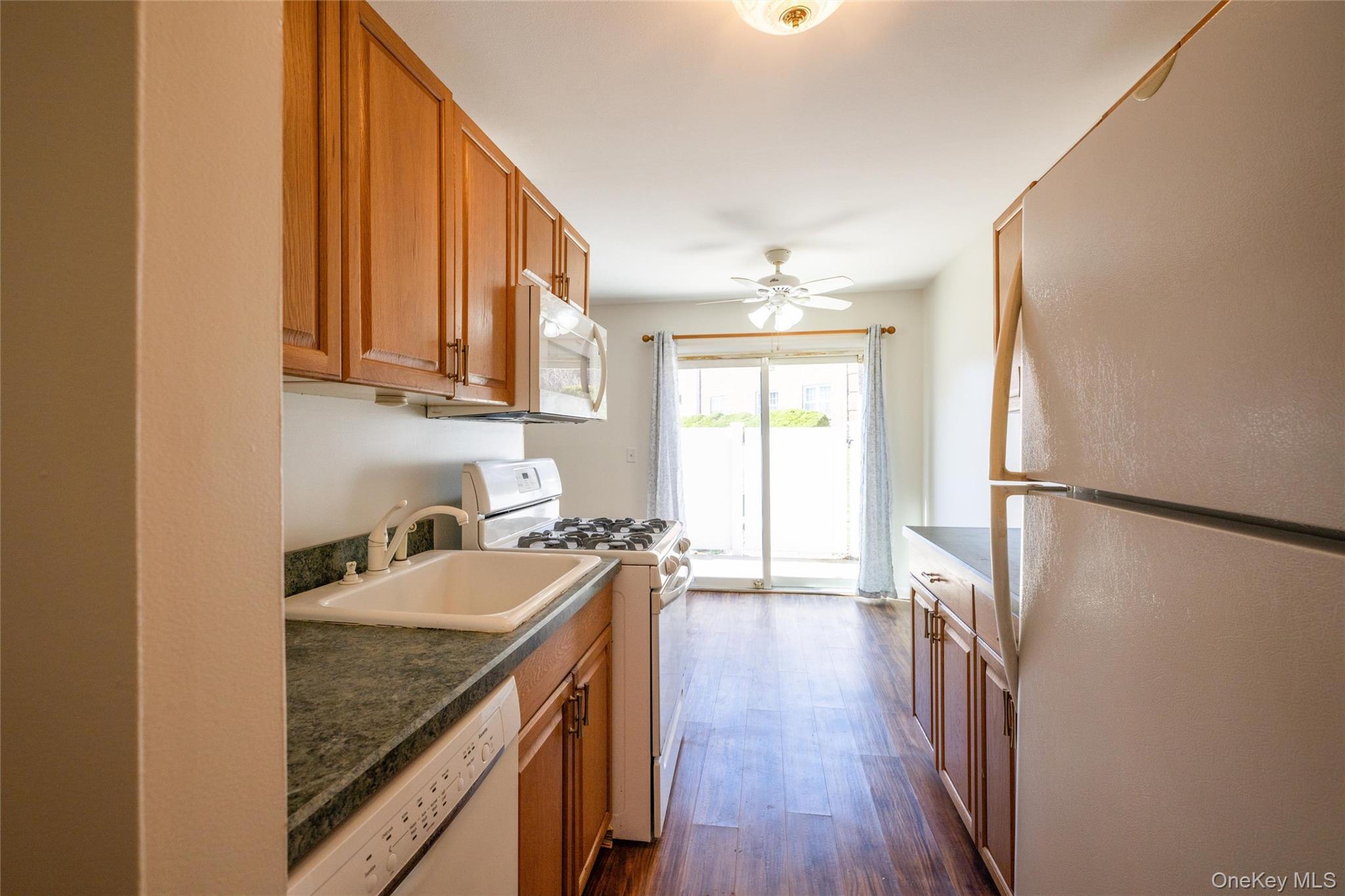460 Old Town Road, Unit 20F Port Jefferson Station, NY 11776 - Photo 7 of 22 a kitchen with a refrigerator a sink and wooden floor