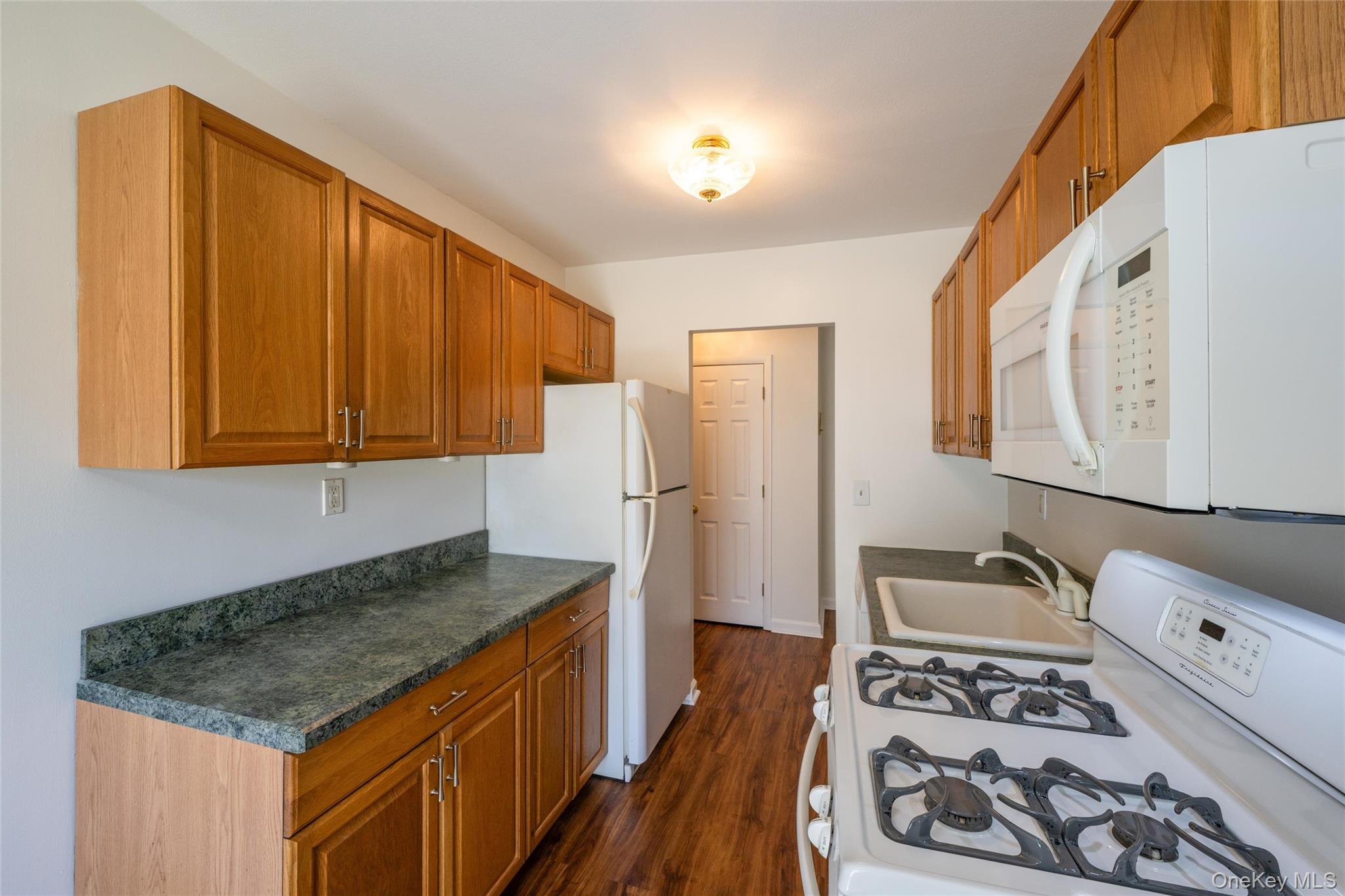 460 Old Town Road, Unit 20F Port Jefferson Station, NY 11776 - Photo 8 of 22 a kitchen with stainless steel appliances granite countertop a stove a sink and a refrigerator
