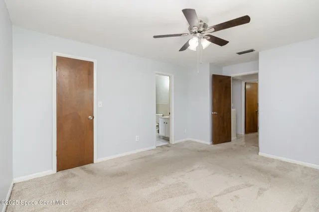 a view of an empty room with a ceiling fan