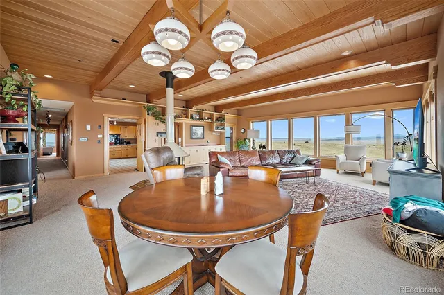 a dining room with furniture and a large window