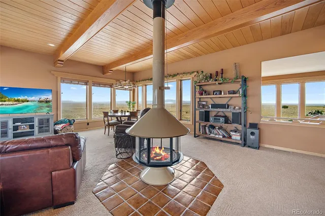 a living room with furniture a chandelier and a large window