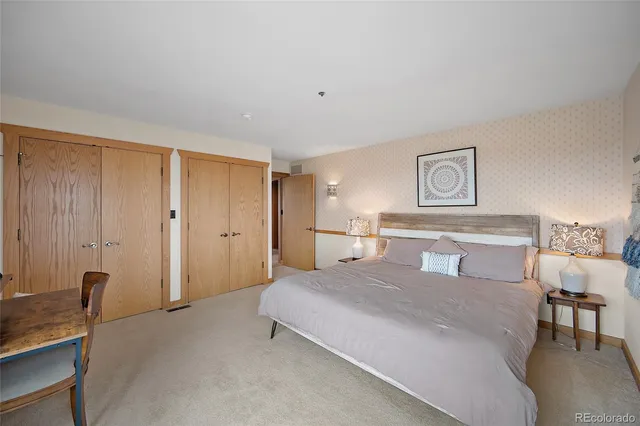 a spacious bedroom with a bed and a table in it