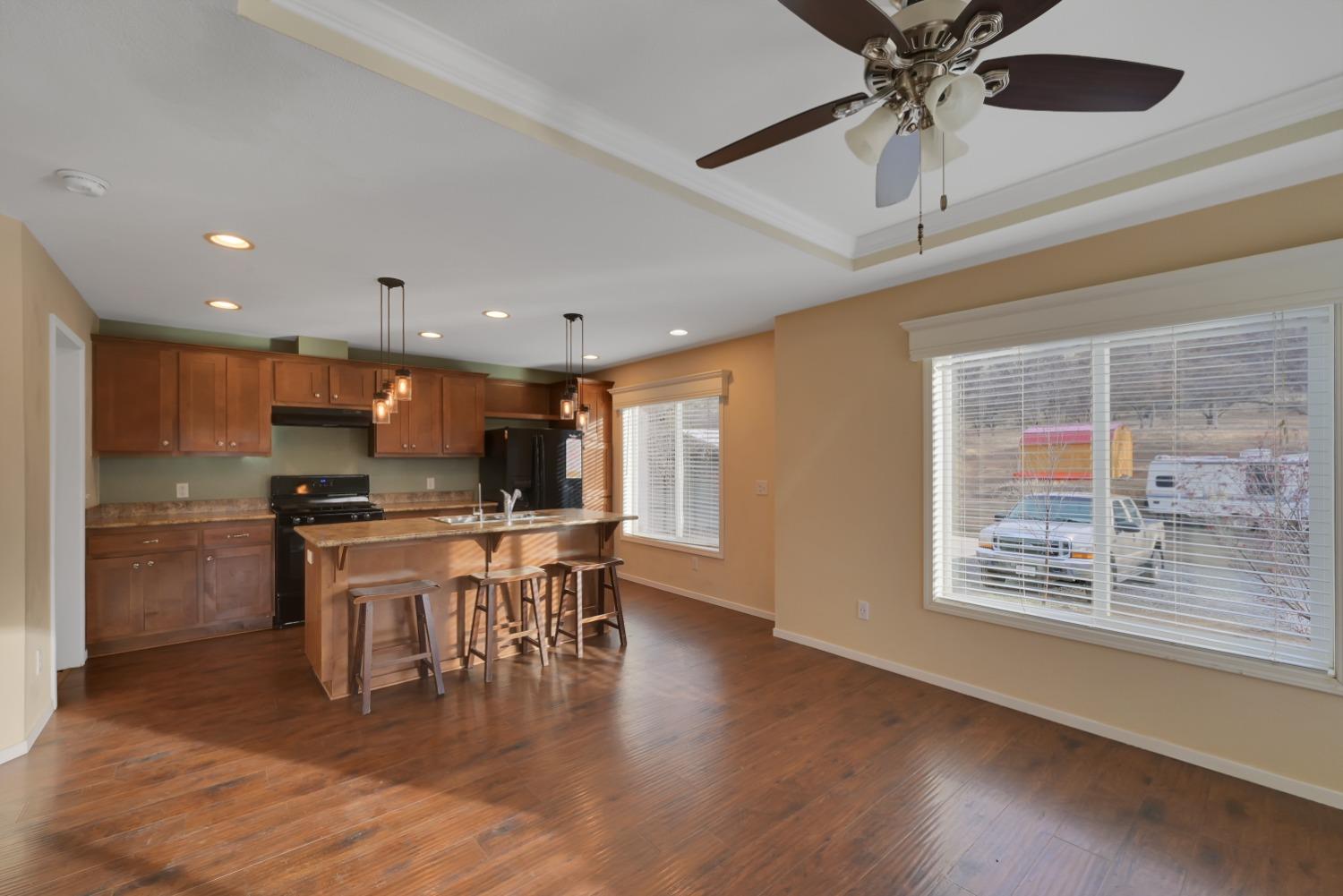 4485 Sites Lodoga Road Stonyford, CA 95979 - Photo 15 of 66 a kitchen with stainless steel appliances granite countertop a stove top oven a refrigerator a dining table and chairs with wooden floor