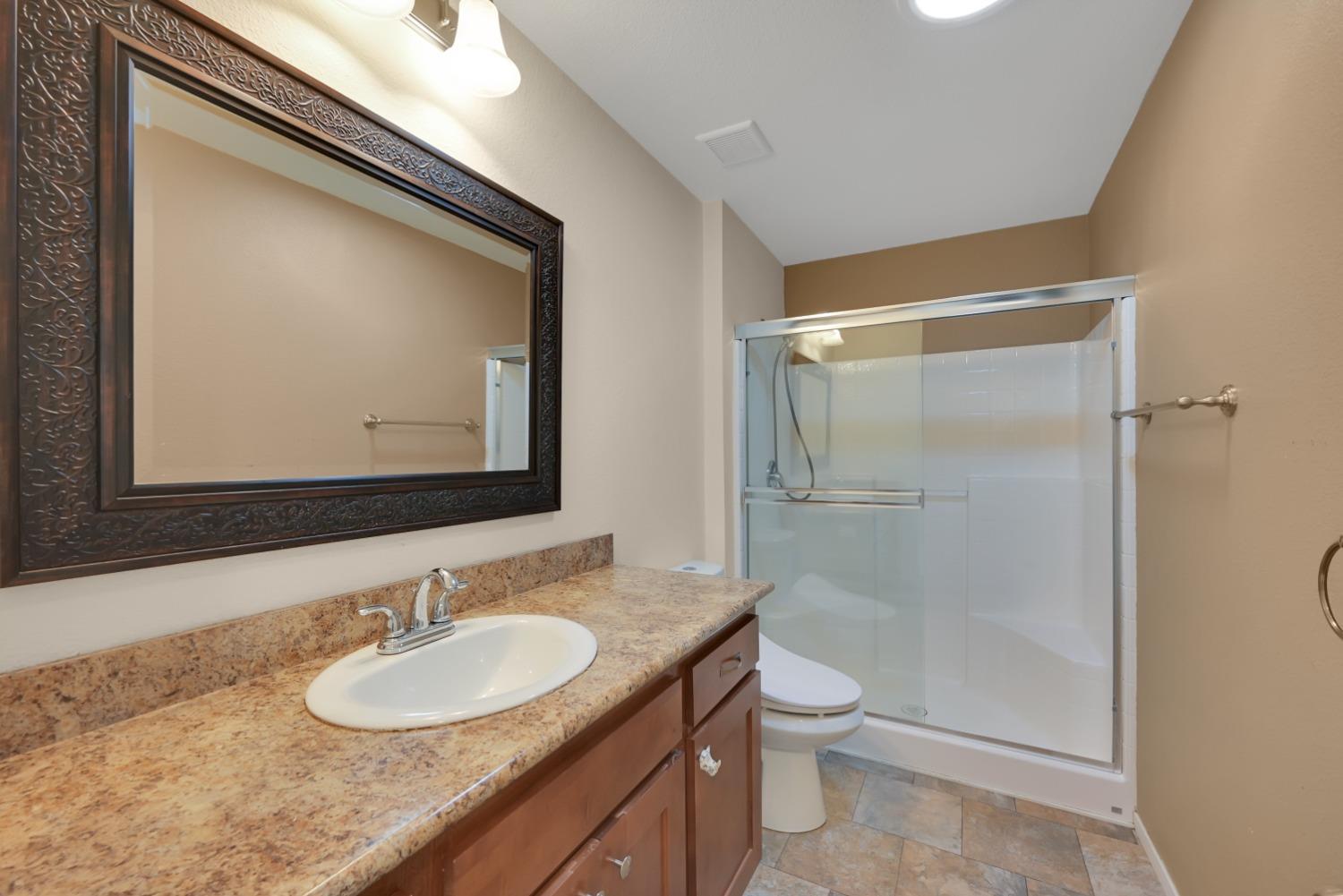 4485 Sites Lodoga Road Stonyford, CA 95979 - Photo 26 of 66 a bathroom with a granite countertop sink a toilet and a mirror