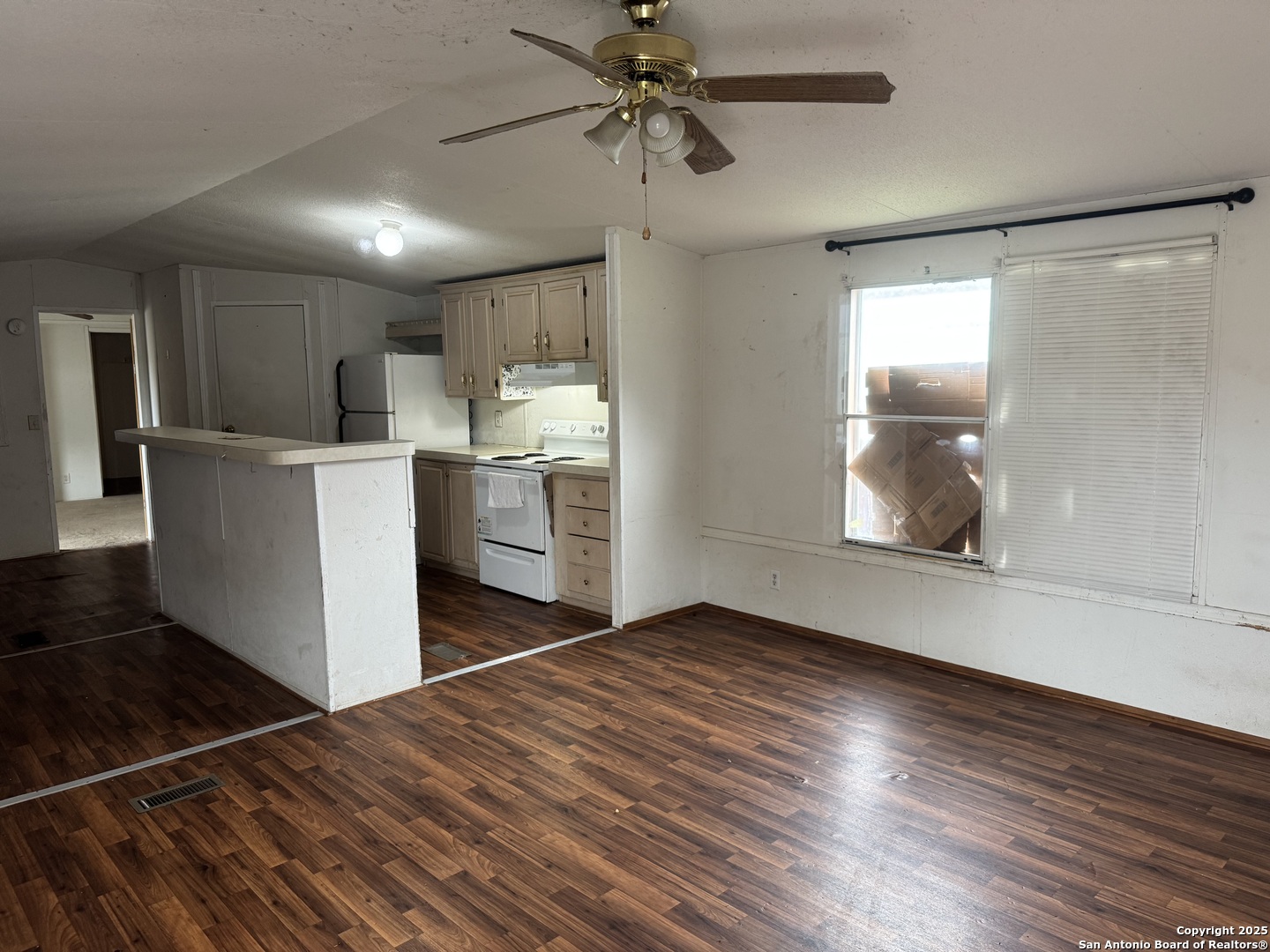 509 Maple Street Jourdanton, TX 78026 - Photo 2 of 14 a view of a kitchen with a sink cabinets and wooden floor