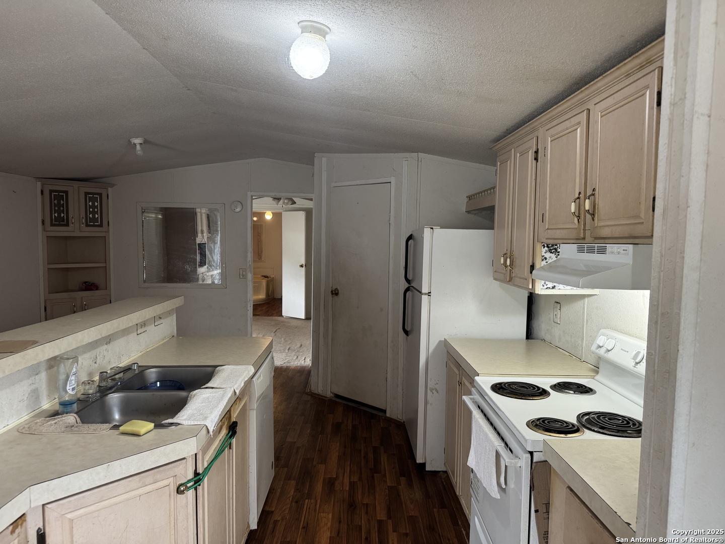 509 Maple Street Jourdanton, TX 78026 - Photo 4 of 14 a kitchen that has a sink and a stove in it