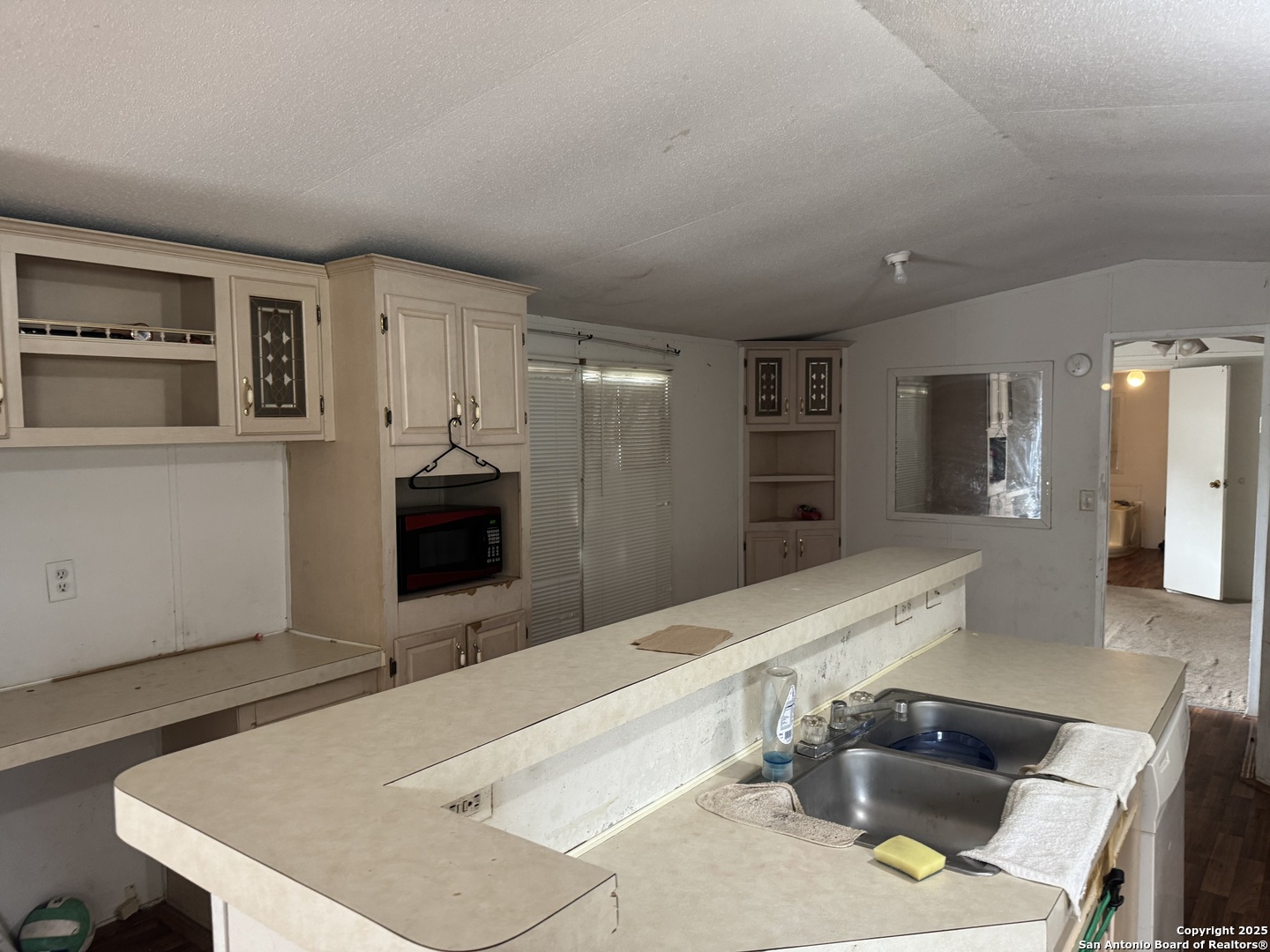 509 Maple Street Jourdanton, TX 78026 - Photo 5 of 14 a large kitchen with kitchen island a sink stainless steel appliances and cabinets