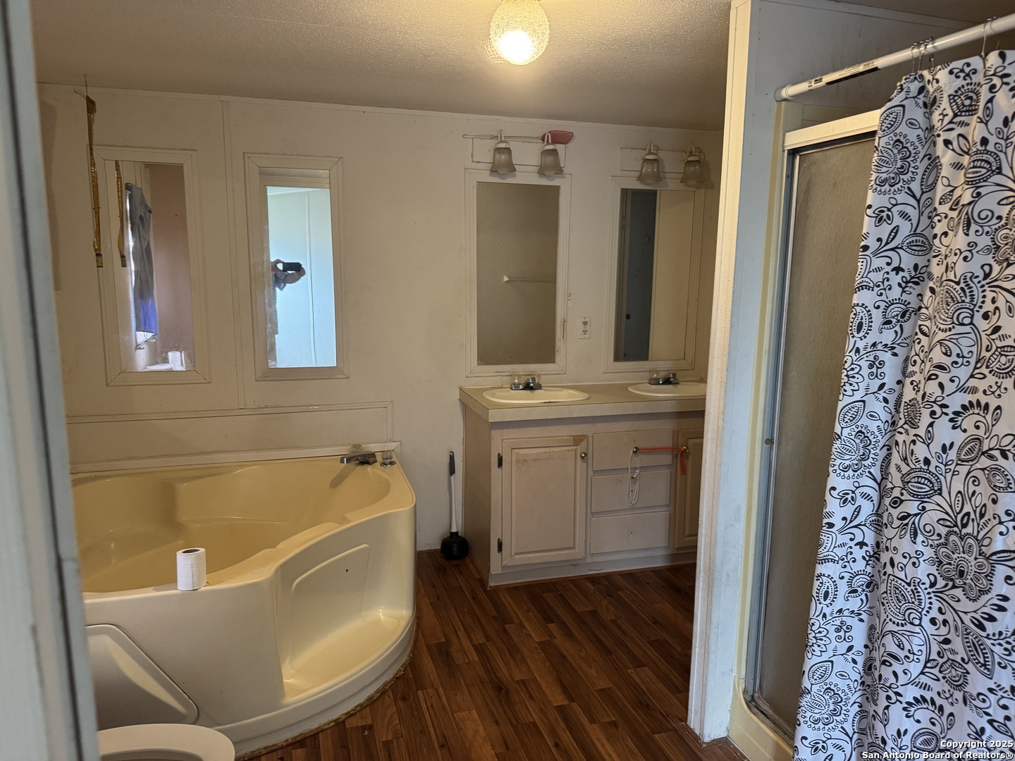 509 Maple Street Jourdanton, TX 78026 - Photo 6 of 14 a bathroom with a tub sink and mirror
