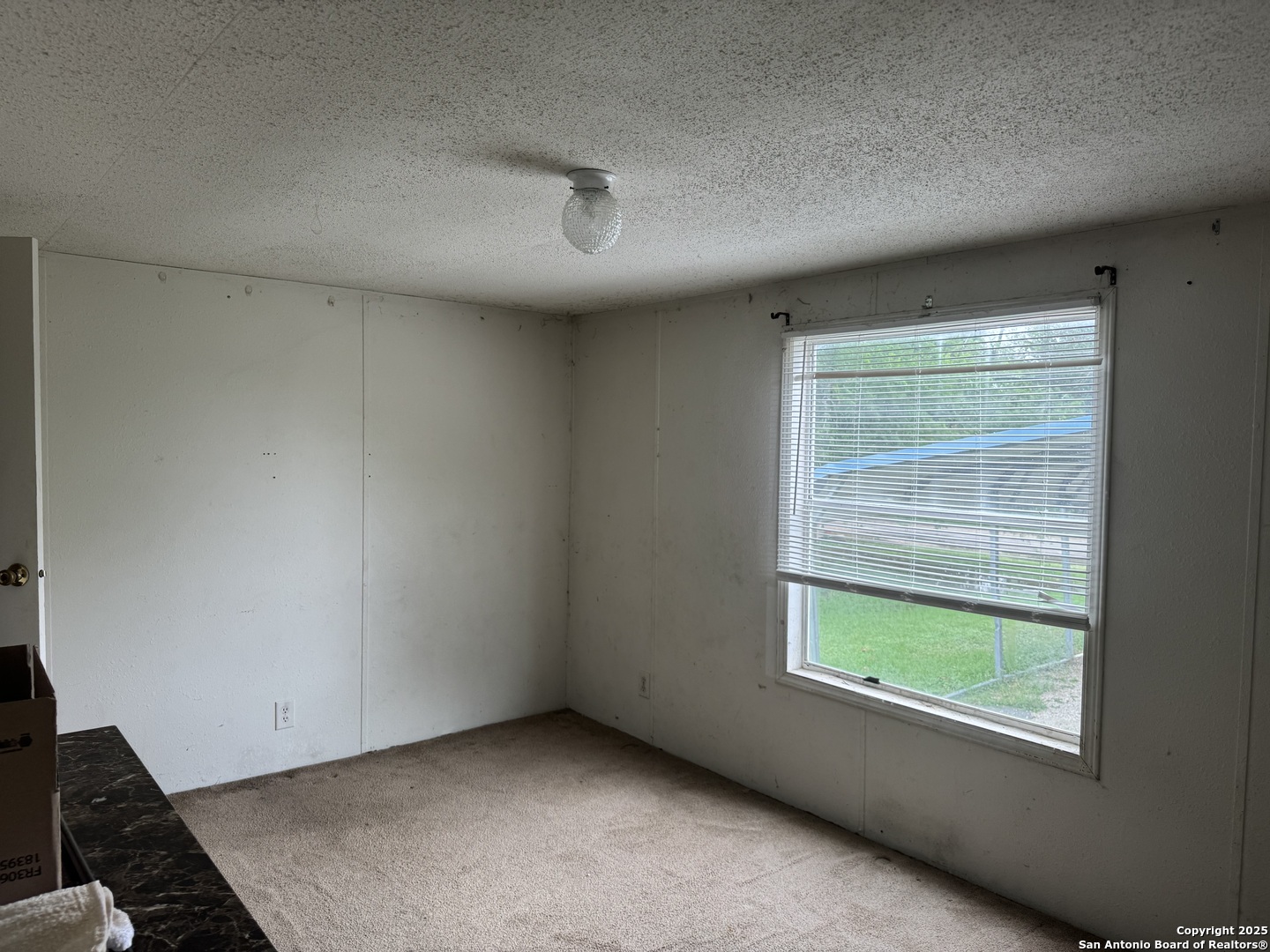509 Maple Street Jourdanton, TX 78026 - Photo 10 of 14 an empty room with a window