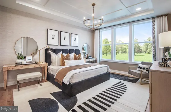 a bedroom with a bed a chandelier a mirror and a window