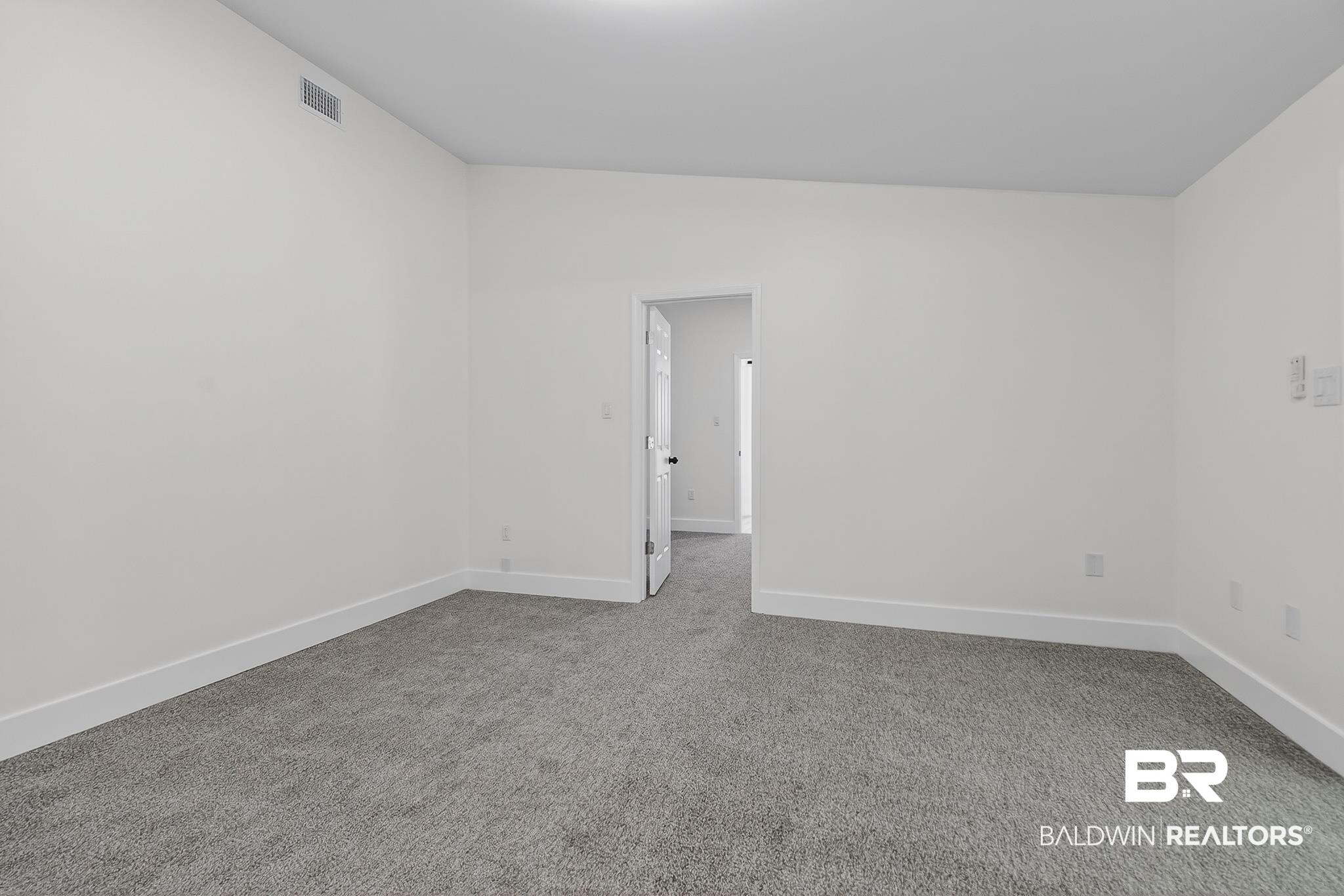 10650 Old Pascagoula Road Theodore, AL 36582 - Photo 63 of 77 Carpeted spare room featuring baseboards and lofted ceiling