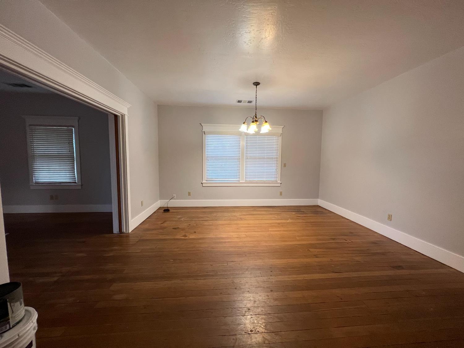 19076 East Central Avenue Reedley, CA 93654 - Photo 10 of 16 an empty room with wooden floor chandelier and windows