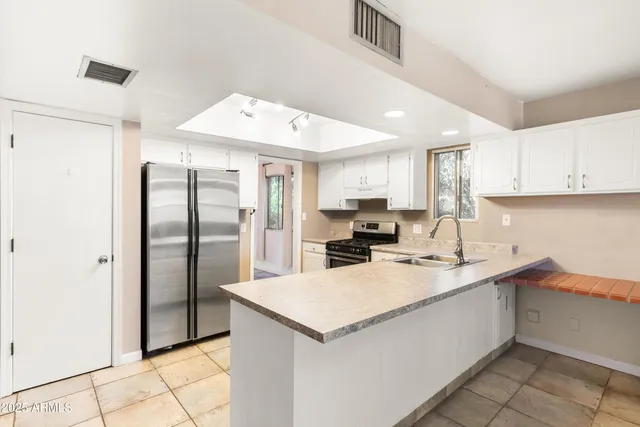 a kitchen with a sink a refrigerator and cabinets