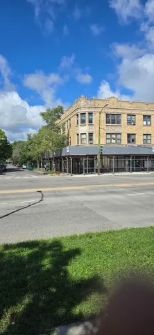 a front view of a building with a yard and outdoor seating